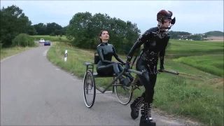 Latex Pony Outdoor. Female latex pony slave outdoor dominated by her Mistress using her whip to guide her in pulling a cart so that her owner can have fun being carried in this way-5