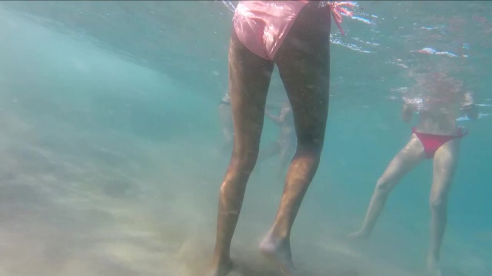 Hot teens playing ball in the ocean